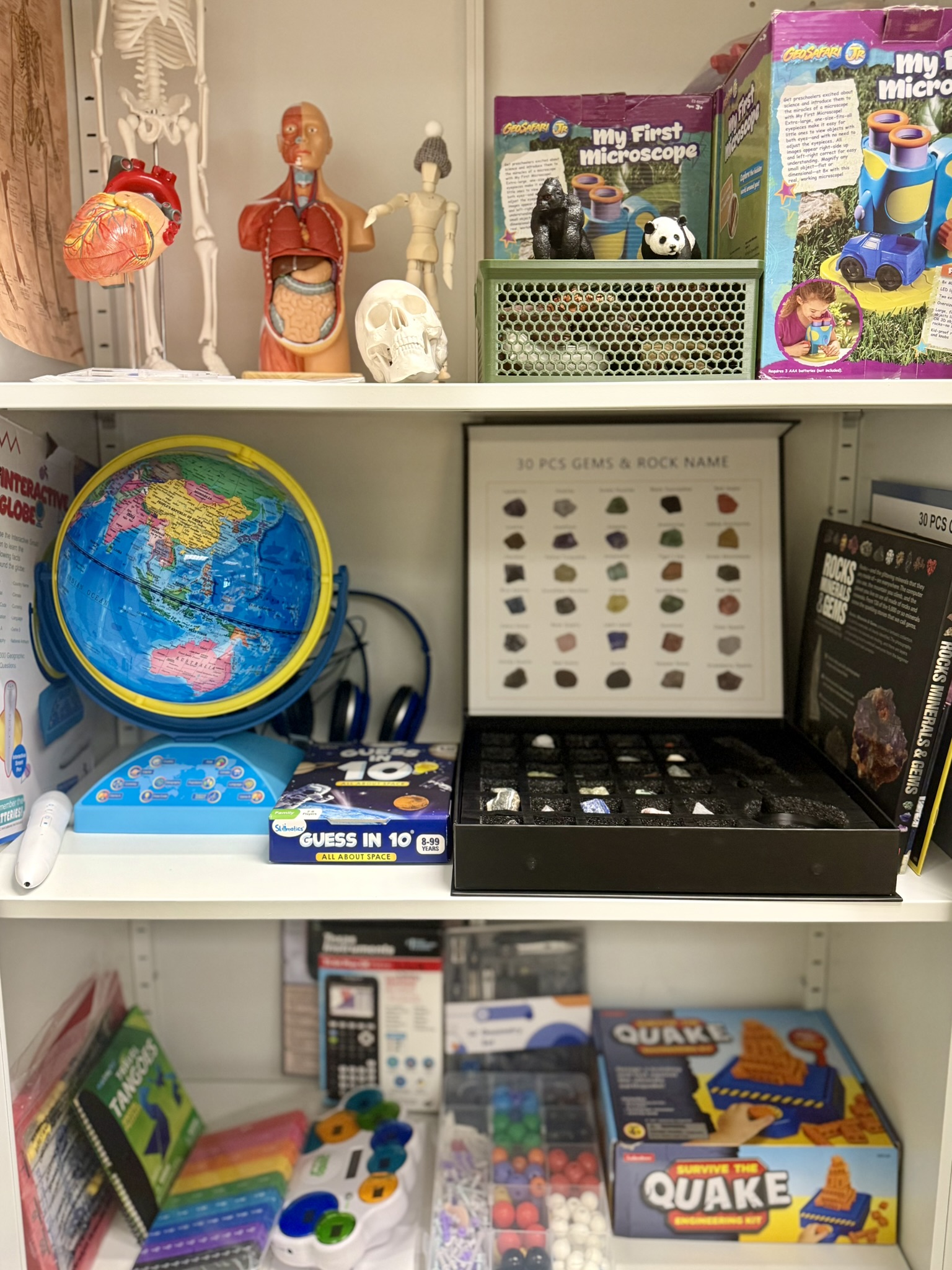 Three shelves filled with colorful STEM learning toys, tools, and games.